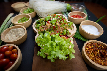 Raw rice flour in a wooden bowl with spices On a dark wood with natural light, focusing on the top...
