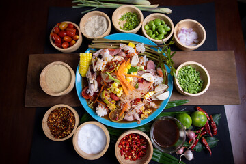 Raw rice flour in a wooden bowl with spices On a dark wood with natural light, focusing on the top of the noodles