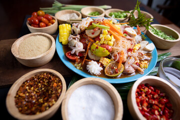 Raw rice flour in a wooden bowl with spices On a dark wood with natural light, focusing on the top of the noodles