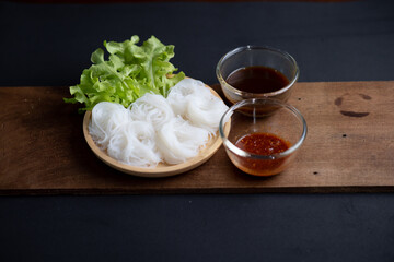 Thai Dried Rice Noodles  in wooden bowl with ingredients for delivery