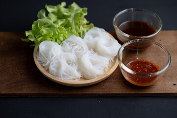 Thai Dried Rice Noodles  in wooden bowl with ingredients for delivery