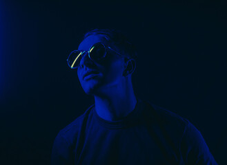 portrait of a man. Male. Neon. Dark background. Sunglasses. 
