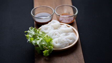 Thai Dried Rice Noodles  in wooden bowl with ingredients for delivery