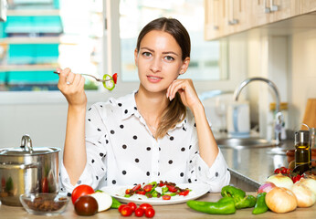 Housewife eating fresh vegetable salad
