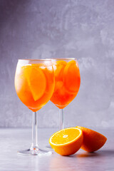 Aperol spritz cocktail on a gray background. Two glasses of aperol spritz with orange slised....