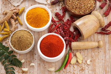Indian masala_chilli, termaric and coriander powder; traditionally arranged on a wooden table