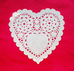 White doily hearts on red background