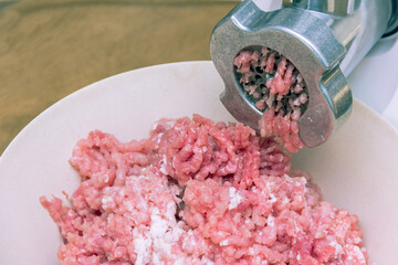 Cooking minced pork meat with a meat grinder. Home-made meat semi-finished products. Minced pork. Semi-finished products for storage in the refrigerator. Meat grinder close up