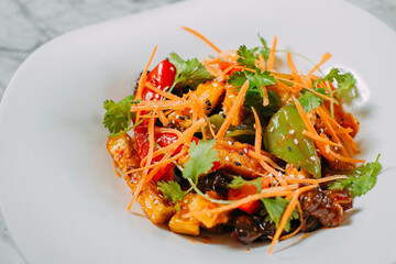 Vegetarian tomato, olives pepper salad in a white plate on a marble table, healthy food