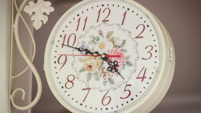 Zoom in clock time lapse start 4:30 and clock walking 30 minutes. White circle antique home clock with floral pattern on wall time lapse. 4k footage without sound. 