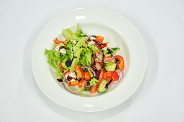 A bowl of salad on a white plate