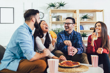 Group of young friends eating pizza in home interior.  Young people having fun together.