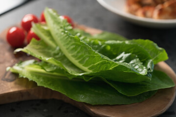 fresh romaine lettuce leaves on wood board