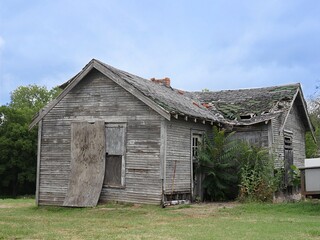  Close up of an abandoned dilapidated wooden house by the side of the road