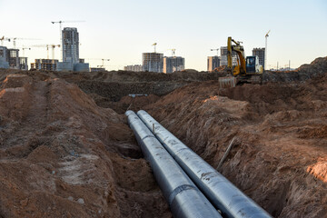 Excavator during construction of main water supply pipeline. Laying underground storm sewers at...