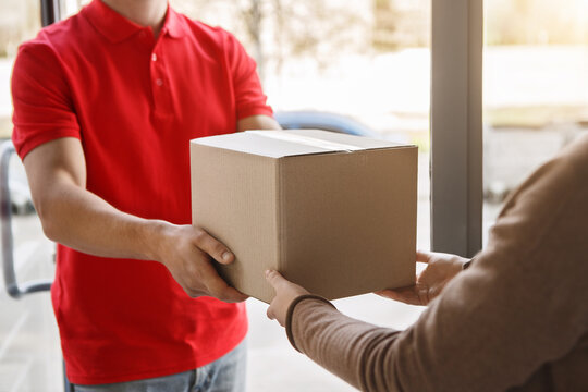 Receive an order without leaving home. Courier gives parcel to girl