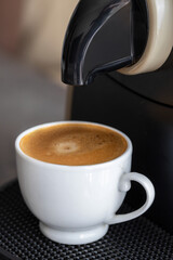 Capsule coffee machine and espresso cup. Making morning espresso concept. Copy space.