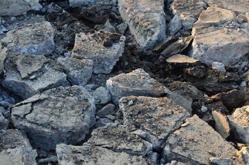 Broken pieces of asphalt at a construction site. Recycling and reuse crushed concrete rubble, asphalt, building material, blocks. Crushed сoncrete Background. Road repair, replacement of old pavement