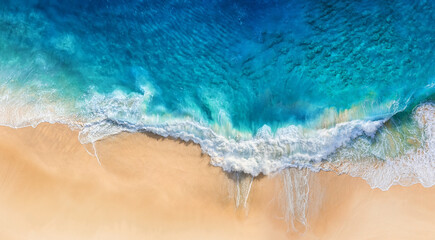 Strand und Wellen als Hintergrund von oben. Hintergrund des blauen Wassers von der Drohne. Sommermeerblick aus der Luft. Reisebild