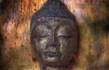 Closeup of  antique Buddha head statue on dreamy background