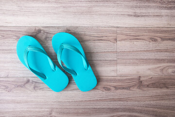 Blue flip flops or .slippers on wooden background.Top view or flat lay background with copy space for text.