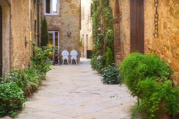 Sunny streets with colorful flowers with contrasting shades. Walk the Tuscan town