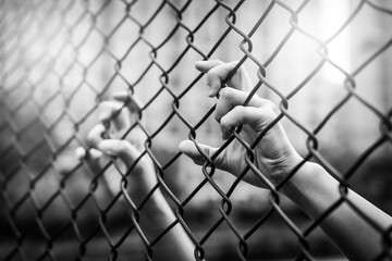 Depressed, trouble and lives matter. Black&White filter, women hand on chain-link fence.