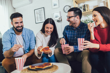 Group of young friends eating pizza in home interior.  Young people having fun together.