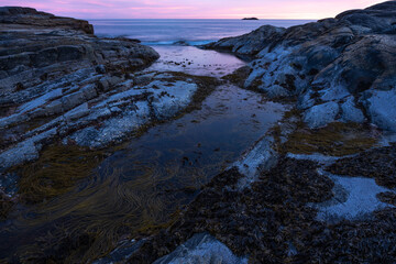 Purple light on smoth rocs by the sea in Norway