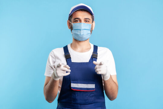 Hey You! Happy Handyman In Overalls, Mask And Gloves Pointing To Camera. Profession Of Service Industry, Courier Delivery, Housekeeping Maintenance. Worker In Uniform Making Choice.indoor, Studio Shot