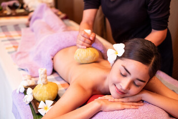 Obraz na płótnie Canvas Young woman having massage with herbal bags in spa salon