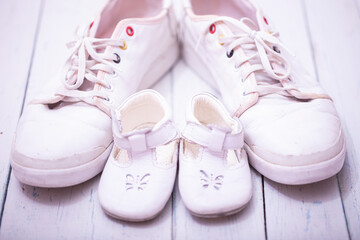 Daddy's baby's sneakers, on white wooden background, fathers day concept.