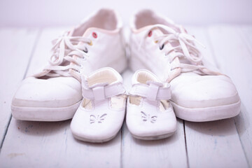 Daddy's baby's sneakers, on white wooden background, fathers day concept.