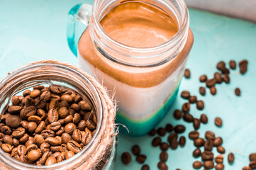 dalgona coffee with coffee beans on a wooden background close up