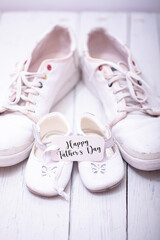 Man's and kid's shoes on white wooden background. Happy father's day concept.