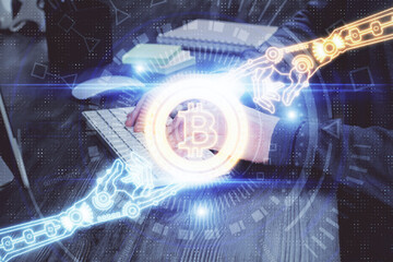 Crypto currency theme hologram with businessman working on computer on background. Concept of...