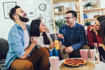 Group of young friends eating pizza in home interior.  Young people having fun together.