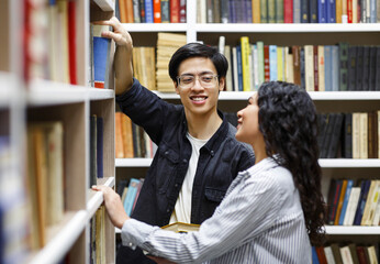 Happy japanese guy taking book at library for his girl