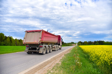 Truck with tipper semi trailer transported sand from the quarry on driving along highway. Modern Dump Semi-Trailer Rear Tipper Truck Trailer