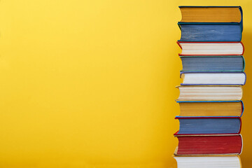 Big book stack on yellow background Education concept Copy space