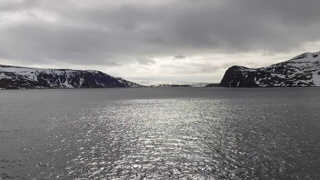 mighty sea and snowy mountain view sailing a ship in Finnmark, northern Norway