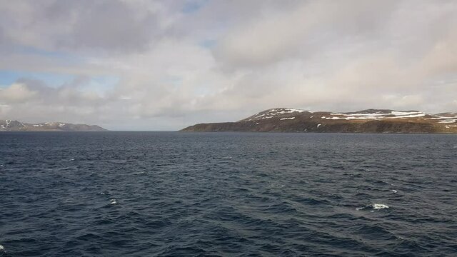 mighty sea and snowy mountain view sailing a ship in Finnmark, northern Norway