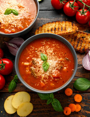 Seasonal vegetables classic minestrone soup with pasta served with cheese, grilled sour dough bread and basil leaves