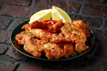 Fried Battered Chicken breast fillets served with lemon wedges
