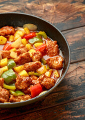 Pineapple and Chicken in sweet and sour sauce with bell pepper, rice and spring onion in pan