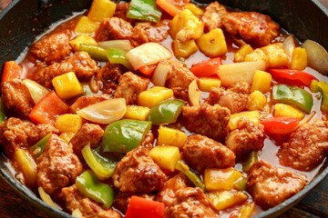 Pineapple and Chicken in sweet and sour sauce with bell pepper, rice and spring onion in pan