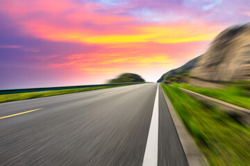 Naklejka premium Motion blurred road and mountains at sunrise.mountain road background.