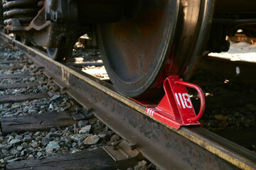 Red railway brake shoe fixed under the rolling stock.