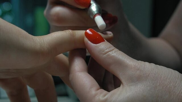 Hardware manicure. Removal of old gel. Manicurist woman removes gel shellac polish from client's nails using manicure machine