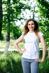 Attractive girl in a white T-shirt on the street. Mock-up.